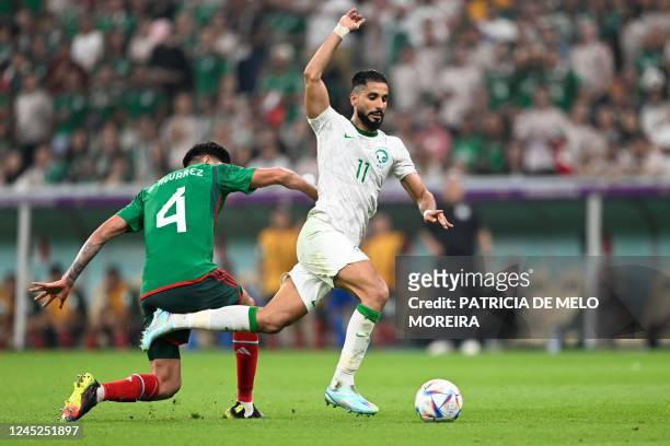 Mexico's midfielder Edson Alvarez fights for the ball with Saudi Arabia's forward Saleh Al-Shehri the Qatar 2022 World Cup Group C football match...