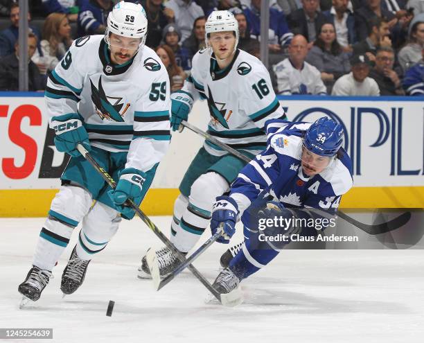 Nick Cicek of the San Jose Sharks skates to avoid a checking Auston Matthews of the Toronto Maple Leafs during an NHL game at Scotiabank Arena on...