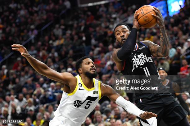 John Wall of the LA Clippers passes around Malik Beasley of the Utah Jazz during the first half of a game at Vivint Arena on November 30, 2022 in...