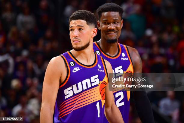 Devin Booker of the Phoenix Suns and Deandre Ayton look on during the game against the Chicago Bulls on November 30, 2022 at Footprint Center in...