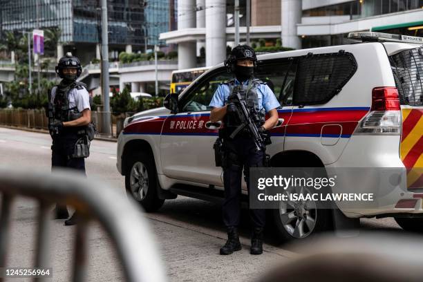 Police stand guard as pro-democracy media tycoon Jimmy Lai arrives in a correctional services van at the high court in Hong Kong on December 1 for...