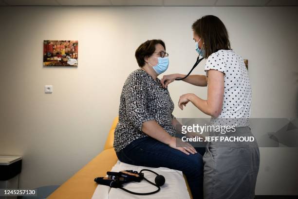 In this photograph taken on November 24, 2022 a doctor examines a patient in the Pontgibaud health house, central France. - Midwives, dermatologists,...