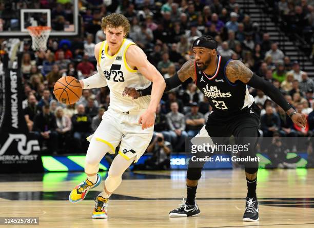 Lauri Markkanen of the Utah Jazz drives past Robert Covington of the LA Clippers during the second half of a game at Vivint Arena on November 30,...
