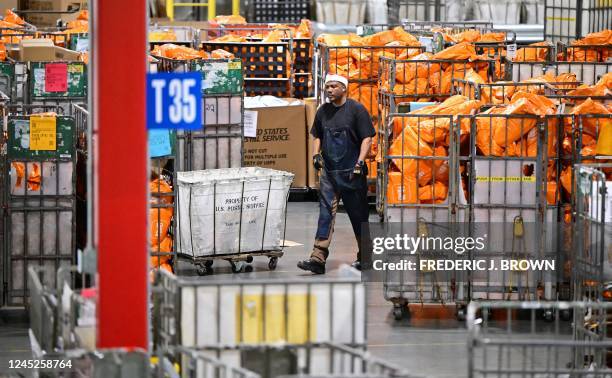 Postal Service employee wearing a Santa hat, walks through sorted mail at the Los Angeles Processing and Distribution Center in preparation for...