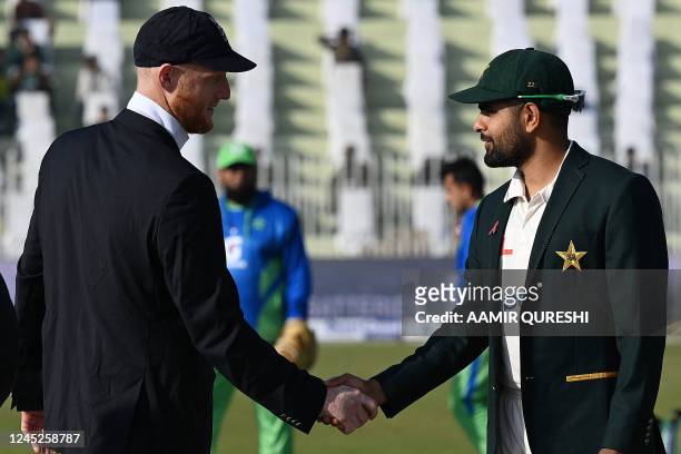 Pakistan's captain Babar Azam shakes hands with his England's counterpart Ben Stokes during toss prior to the start of the first cricket Test match...