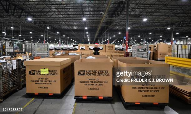 Postal Service employee wearing a Santa hat, sorts mail at the Los Angeles Processing and Distribution Center in preparation for another busy holiday...