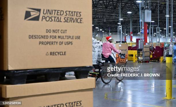 Postal Service employee wearinga Santa hat, bikes through the Los Angeles Processing and Distribution Center where mail is sorted in preparation for...