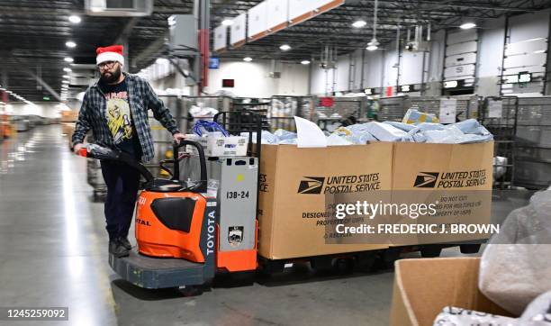 Postal Service employee wearing a Santa hat, sorts mail at the Los Angeles Processing and Distribution Center in preparation for another busy holiday...