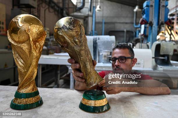 Personnel works on World Cup trophies at the GDE Bertoni headquarters in Milan, Italy on November 21, 2022. GDE Bertoni headquarters is a small...