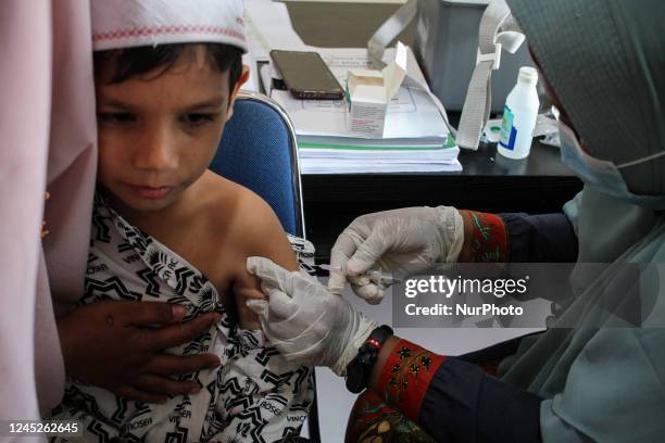 Health workers inject students with the Diphtheria and Tetanus vaccines during child immunization at an elementary school in Lhokseumawe City, on...