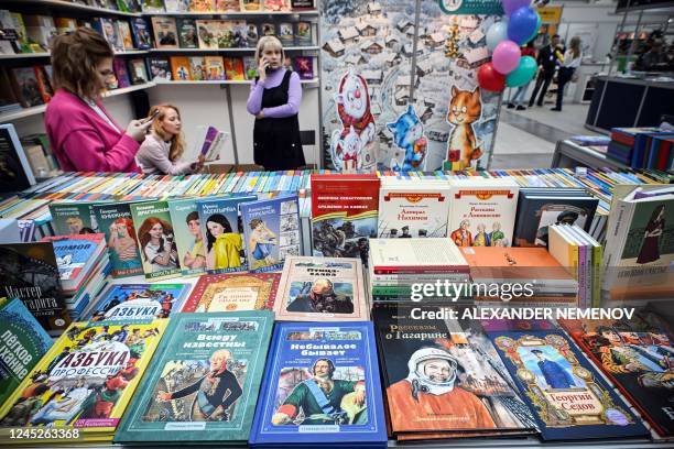 Vendors wait for customers on the first day of an annual high quality fiction and non-fiction book fair in Moscow on December 1 as law increasing...