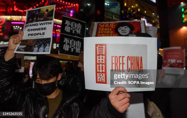 Protesters hold placards during a vigil in Seoul commemorating victims of China's Covid Zero policy. South Korean protesters took to the streets of...