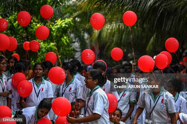 Students hold balloons as they take part in an awareness campaign on the occassion of 'World Aids Day' at Health and Family Welfare Training centre...