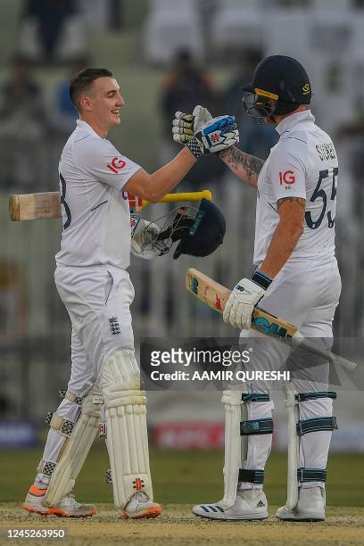 England's Harry Brook celebrates with captain Ben Stokes after scoring a century during the first day of the first cricket Test match between...