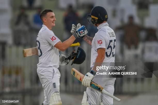 England's Harry Brook celebrates with captain Ben Stokes after scoring a century during the first day of the first cricket Test match between...