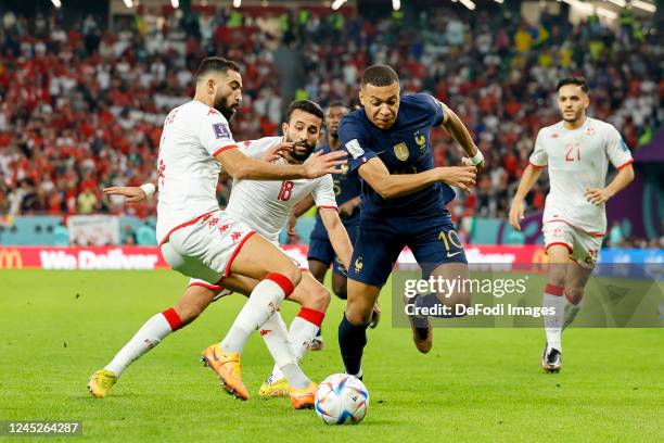 Yassine Meriah of Tunisia, Ghaylen Chaaleli of Tunisia and Kylian Mbappe of France battle for the ball during the FIFA World Cup Qatar 2022 Group D...