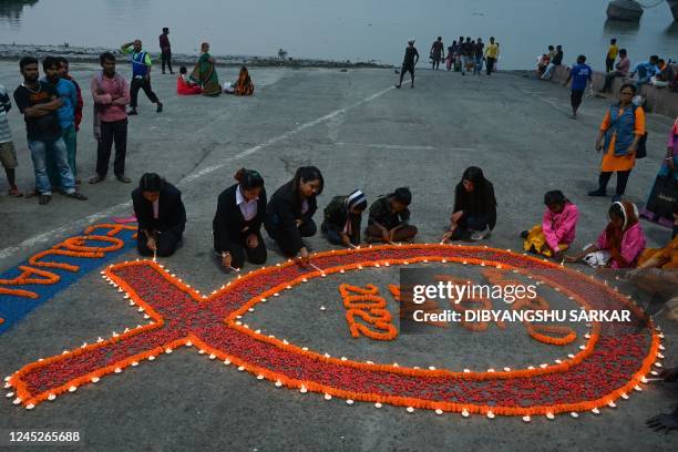 Social activists light up candles arranged along a ribbon symbol during an awareness campaign organised to observe World AIDS Day in Kolkata on...