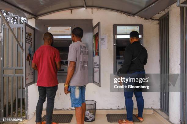 Customers use automatic teller machines at a branch of United Bank of Africa Plc in the Ojuelegba district of Lagos, Nigeria, on Wednesday, Nov. 23,...