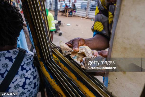 Bus driver collects Nigerian naira from passengers at a bus stop in the Ojuelegba district of Lagos, Nigeria, on Wednesday, Nov. 23, 2022. Nigeria's...