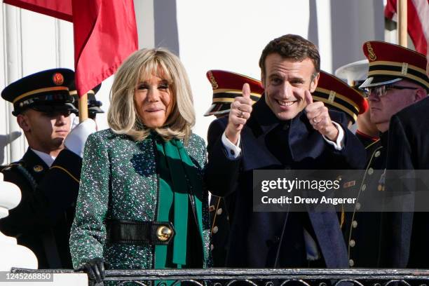French President Emmanuel Macron and his wife Brigitte Macron react to the crowd on the South Lawn of the White House during an official state visit...