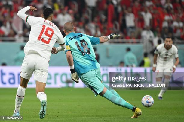 Canada's goalkeeper Milan Borjan clears the ball before Morocco's midfielder Hakim Ziyech scores his team's first goal during the Qatar 2022 World...