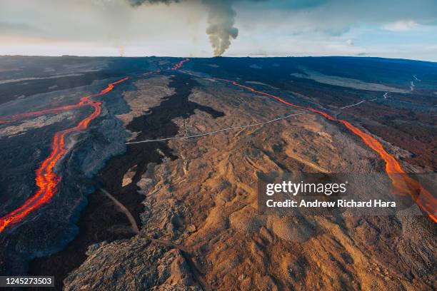 In this aerial view, lava fissures flow downslope from the north flank of Mauna Loa Volcano as it erupts on November 30, 2022 near Hilo, Big Island...