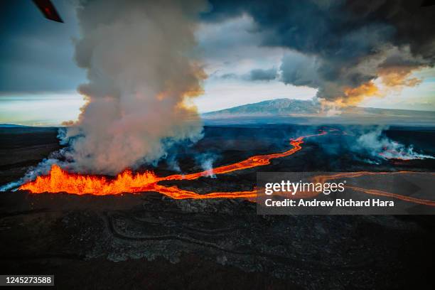 In this aerial view, lava fissures flow downslope from the north flank of Mauna Loa Volcano as it erupts on November 30, 2022 near Hilo, Big Island...