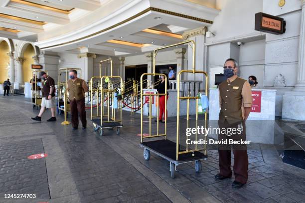 Hotel bellhops stand ready to receive guests at Caesars Palace on the Las Vegas Strip as the property opens for the first time since being closed on...