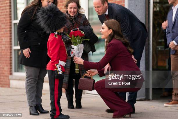 Britain's Prince William, Prince of Wales, and Catherine, Princess of Wales are presented with flowers by Henry Dynov-Teixeira, aged 8, dressed as a...