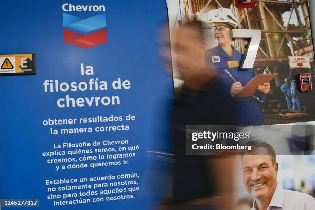 Worker passes signage at the Chevron Corp. Offices in Caracas, Venezuela, on Thursday, Dec. 1, 2022. The Biden administration granted Chevron a...