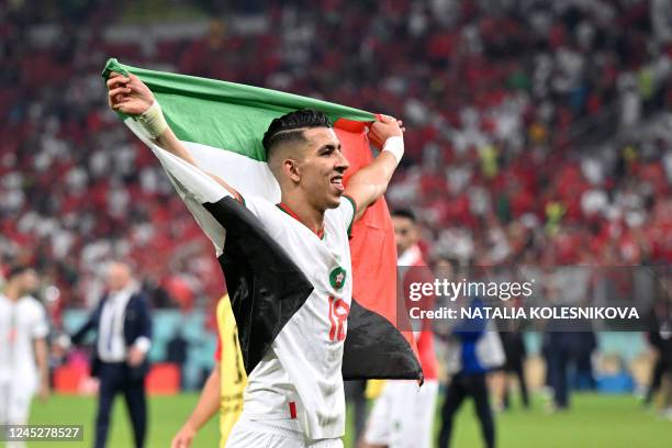 Morocco's defender Jawad El Yamiq waves the Palestinian flag after his team the Qatar 2022 World Cup Group F football match between Canada and...