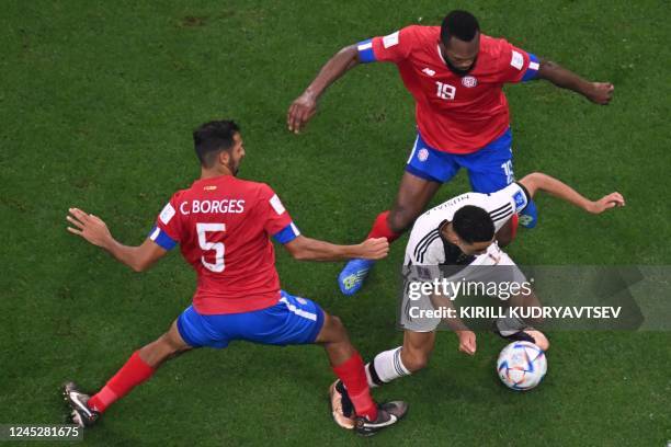 Germany's midfielder Jamal Musiala fights for the ball with Costa Rica's midfielder Celso Borges and Costa Rica's defender Kendall Waston during the...