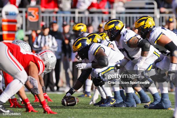 Michigan Wolverines and Ohio State Buckeyes players line up at the line of scrimmage before the snap during a college football game on November 26,...