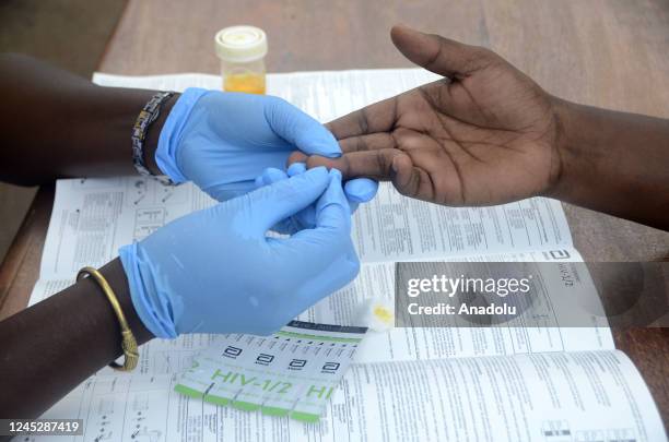 Group of volunteer health workers take blood samples from participant for AIDS tests within the events of December 1 World AIDS Day in Kampala,...