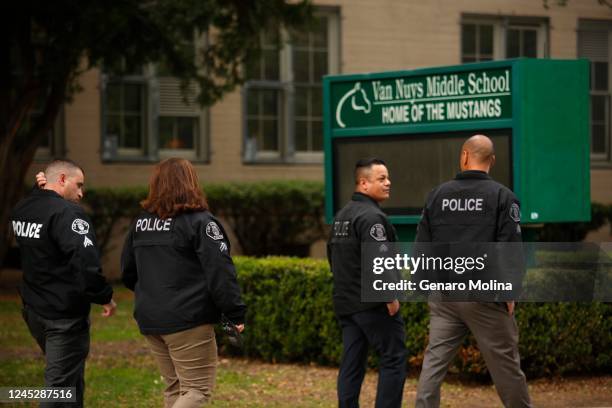 Police officers walk in front of Van Nuys Middle School where at least eight students from Van Nuys Middle School were treated for possible overdoses...