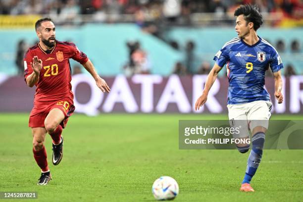 Spain's defender Dani Carvajal and Japan's forward Kaoru Mitoma look at each other as they run for the ball during the Qatar 2022 World Cup Group E...