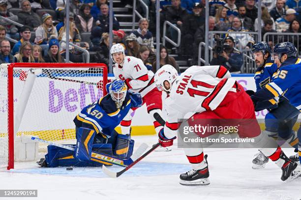 St. Louis Blues goaltender Jordan Binnington kicks out the right leg to make a pad save on the shot by Carolina Hurricanes center Jordan Staal during...