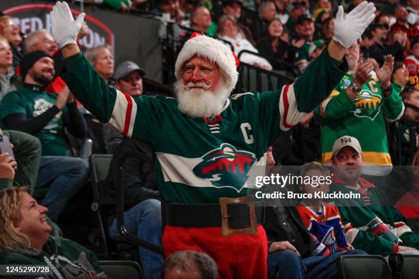 Fan dressed as Santa Claus waves to the crowd during the game between the Minnesota Wild and the Edmonton Oilers at the Xcel Energy Center on...