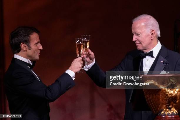 President Joe Biden and French President Emmanuel Macron toast their glasses after speaking at the state dinner on the South Lawn of the White House...