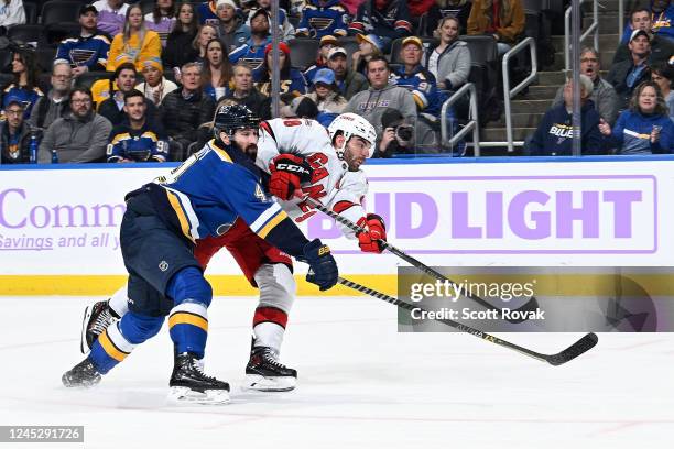 Jordan Martinook of the Carolina Hurricanes shoots and scores as Nick Leddy of the St. Louis Blues attempts to defend at the Enterprise Center on...