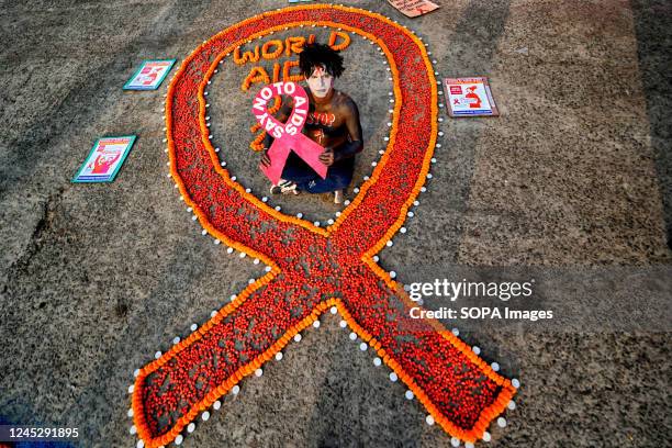 Young demonstrator with a painted face poses for a photo during the World AIDS Day awareness campaign. World AIDS Day is observed annually on...
