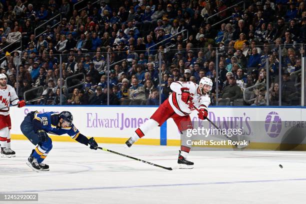 Jordan Staal of the Carolina Hurricanes scores an empty net goal as Jordan Kyrou of the St. Louis Blues attempts to defend at the Enterprise Center...