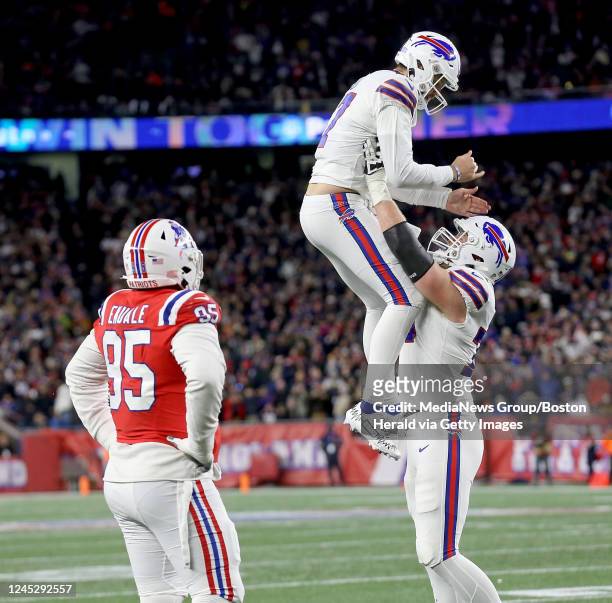 December 1: Hunter Henry of the New England Patriots watches as Josh Allen of the Buffalo Bills celebrates his touchdown throw with Spencer Brown...