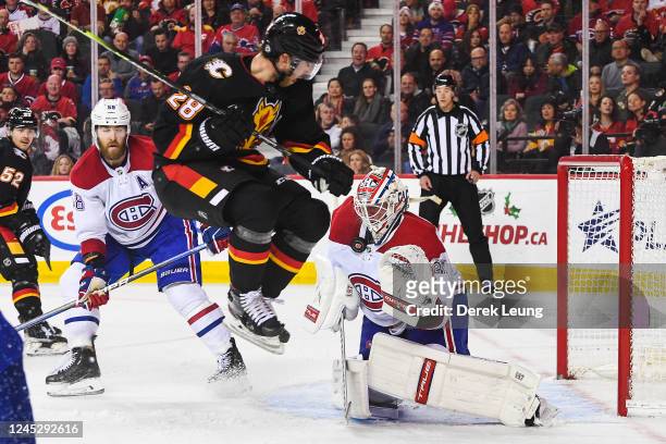 Elias Lindholm of the Calgary Flames jumps to get out of the way of a shot on Jake Allen of the Montreal Canadiens during the third period of an NHL...