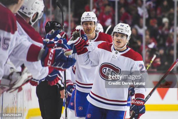Cole Caufield of the Montreal Canadiens celebrates with the bench after scoring against the Calgary Flames during the third period of an NHL game at...