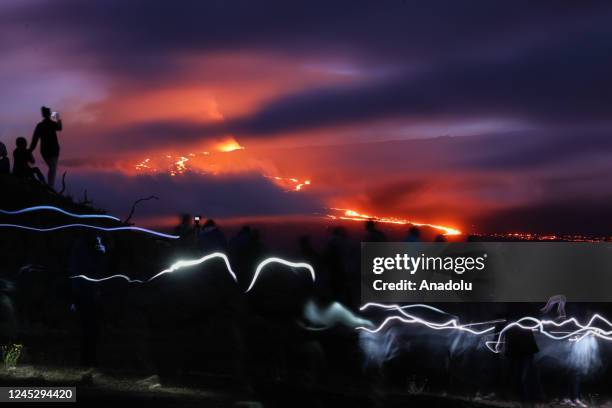 People gather on top of a hill to watch Mauna Loa erupts, the world's largest active volcano on December 1, 2022 in Big Island of Hawaii, United...