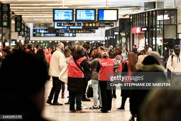 Employees help commuters at Gare de Montparnasse in Paris, on December 2, 2022 during a strike organised by SNCF controllers - Complicated weekend in...