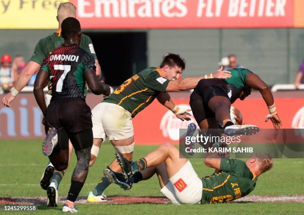 Pretorius and Impi Visser of South Africa are tackled by Willy Ambaka And Tony Omondi of Kenya during a match of the HSBC World Rugby Sevens Series...