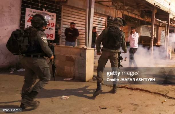 Member of the Israeli security forces throws an object towards Palestinian Ammar Hadi Mufleh as Israeli border guards deploy in the occupied West...