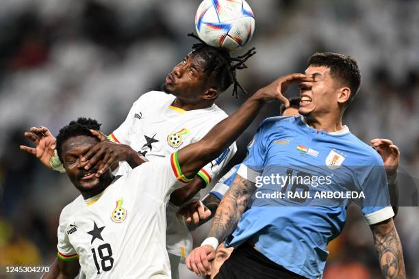 Ghana's defender Daniel Amartey, Ghana's defender Mohammed Salisu and Uruguay's defender Mathias Olivera fight for a header during the Qatar 2022...